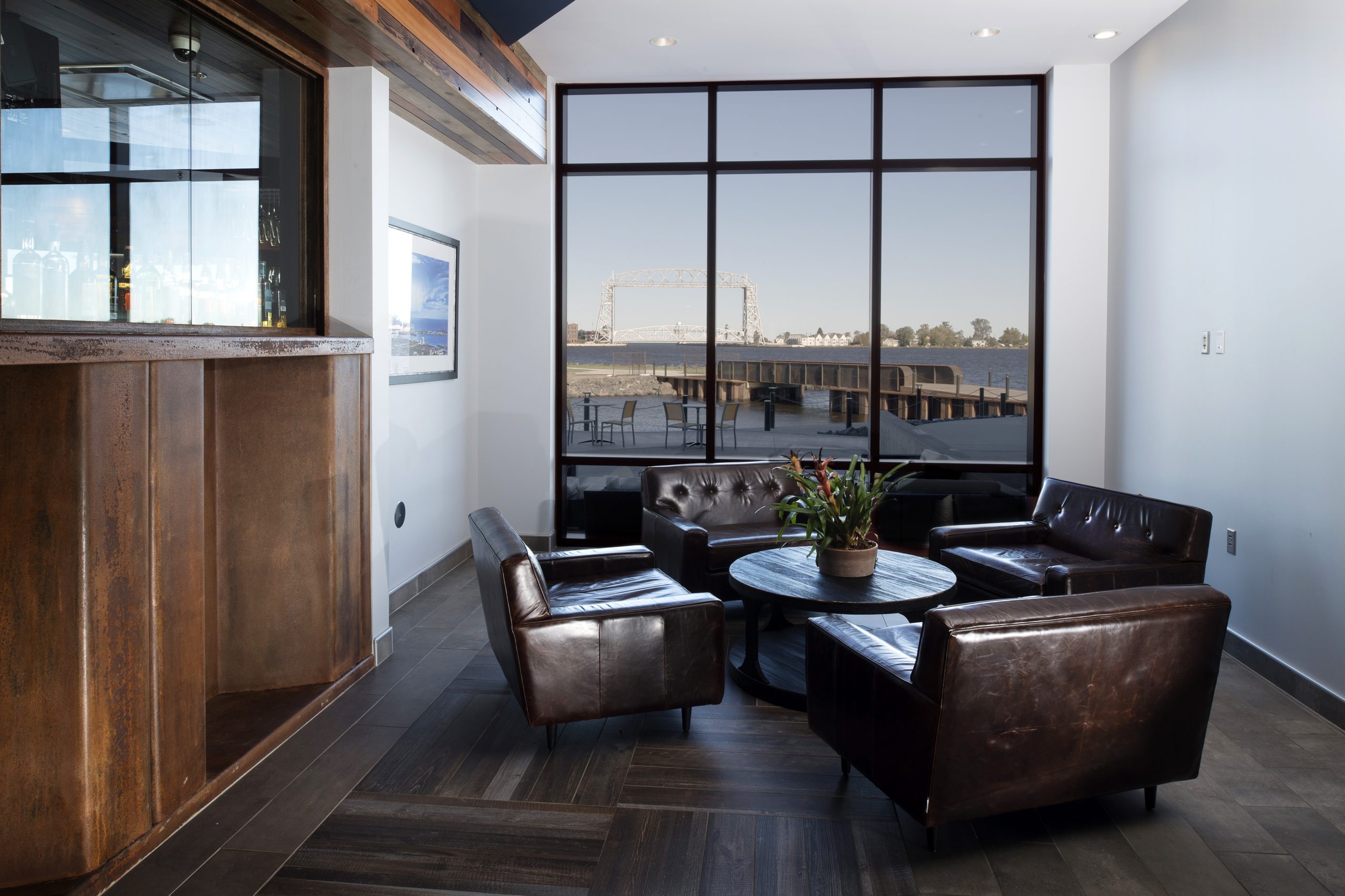 Sleek finishes are juxtaposed with salvaged material, such as the bar façade which is made up of a large piece of corrugated metal.