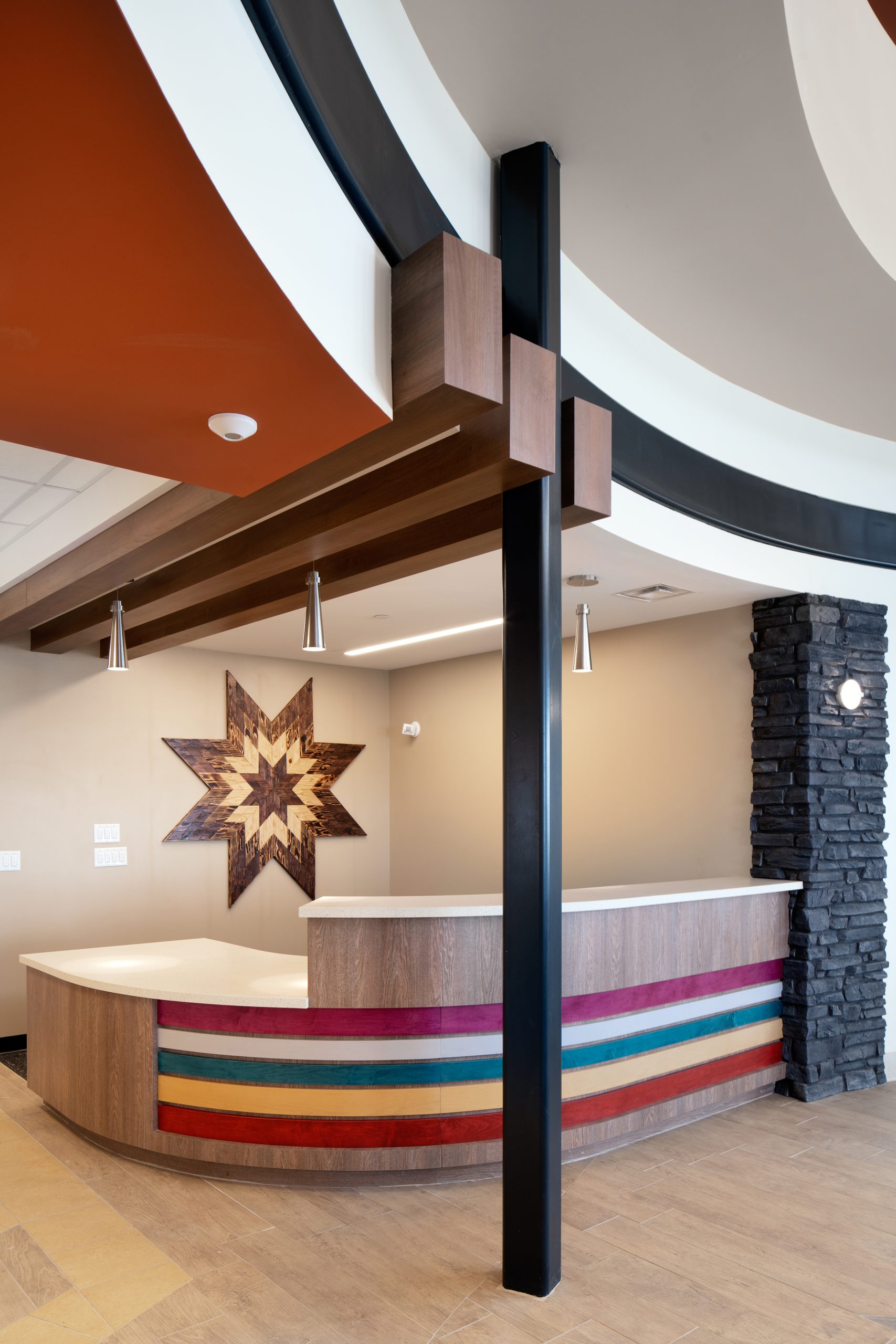 The reception desk features colorful strips resembling a ribbon dress.