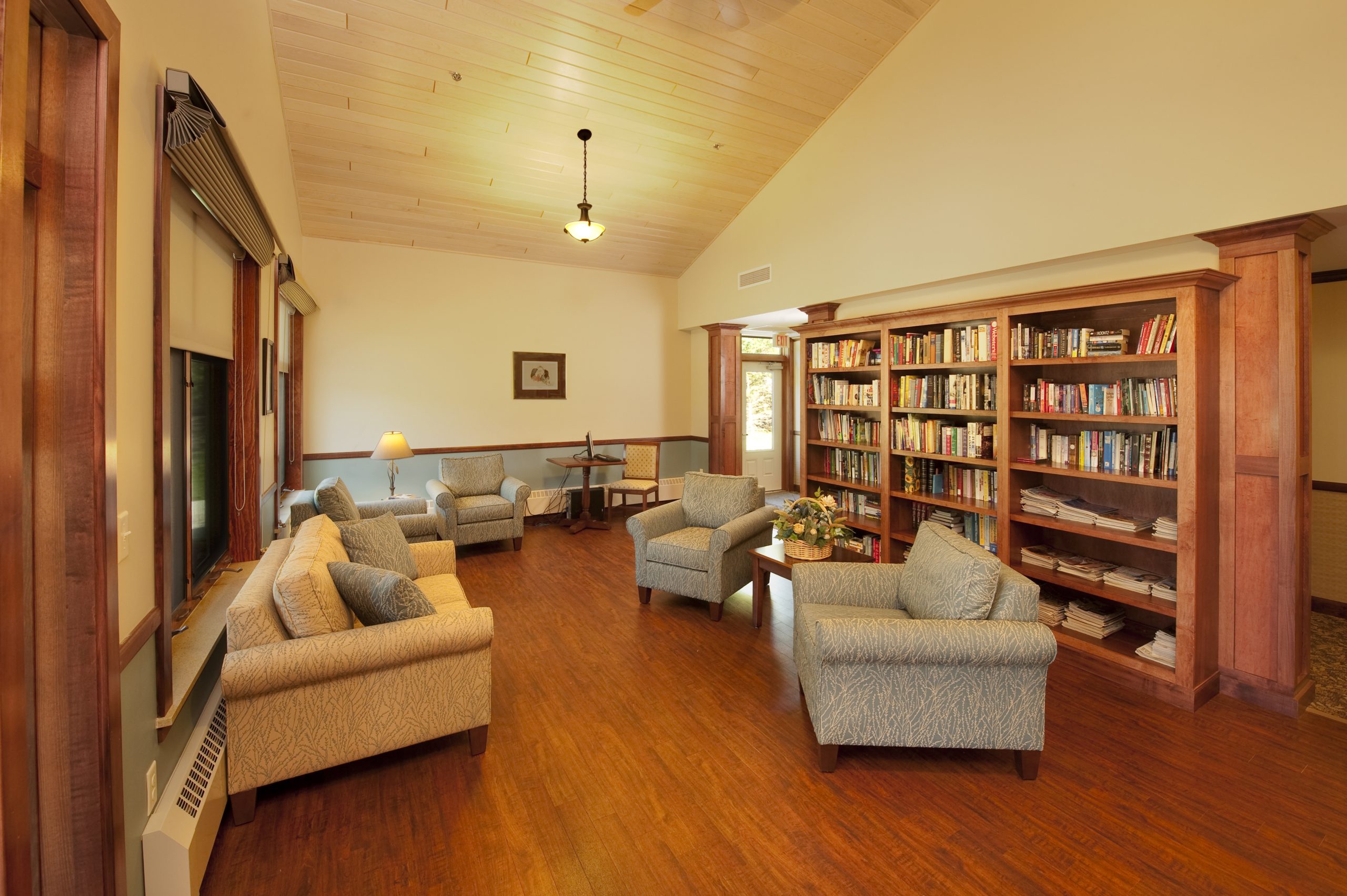 The library, with custom bookshelves and cupboards, has direct access to the 3-season room providing reading area options.