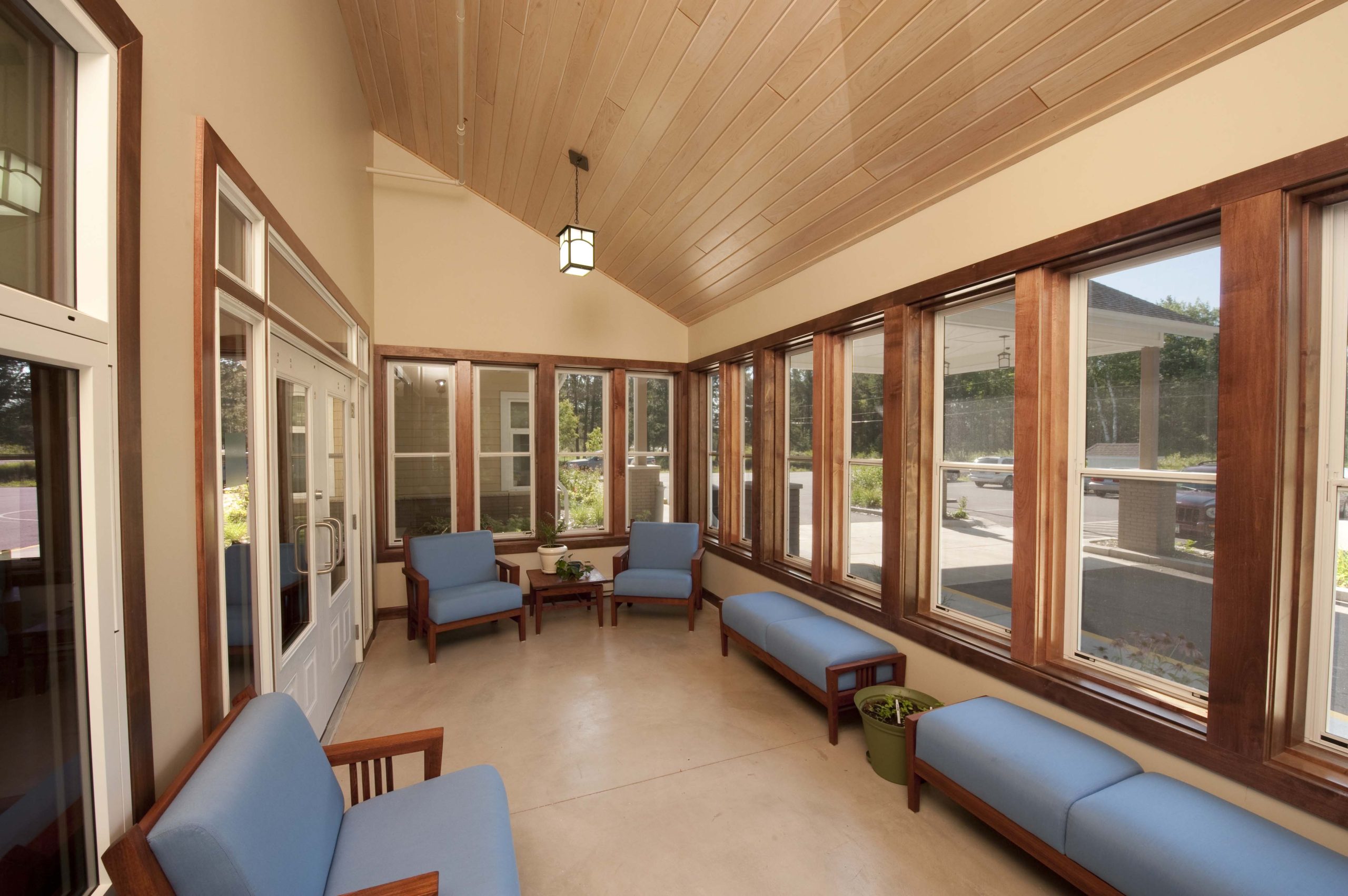 The south-facing 3-season room features custom, outdoor grade furniture for residents to relax and take in some sunshine.