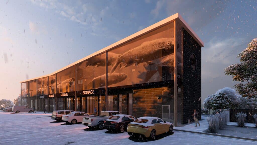 A modern two-story building with large glass windows at sunset, displaying images of whales inside. Several parked cars and snow-covered ground and trees are visible, suggesting a winter scene.
