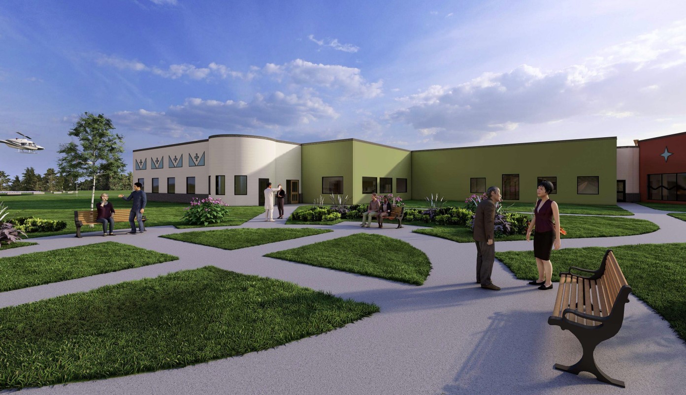 People are gathered and talking in a landscaped courtyard outside a modern building with green and beige walls, benches, and pathways. A helicopter is visible in the sky in the background. The scene is bright and sunny.