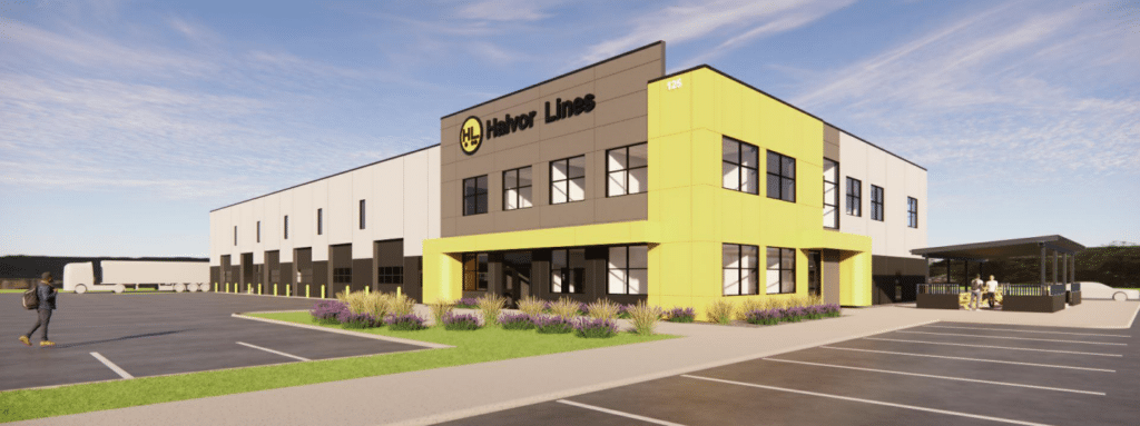 A modern, two-story commercial building with "Habor Lines" signage, featuring yellow and gray accents, large windows, and a parking lot with landscaped greenery under a blue sky.
